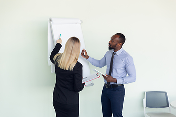 Image showing Young businessman working with colleague using flipchart, copyspace