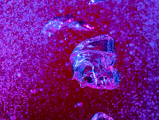 Image showing Close up view of the cold and fresh cola with bright bubbles in neon light