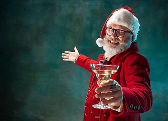 Image showing Modern stylish Santa Claus in red fashionable suit and cowboy\'s hat on dark background