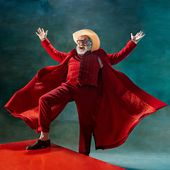 Image showing Modern stylish Santa Claus in red fashionable suit and cowboy\'s hat on dark background