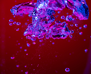 Image showing Close up view of the cold and fresh cola with bright bubbles in neon light