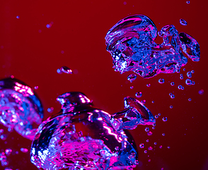 Image showing Close up view of the cold and fresh cola with bright bubbles in neon light