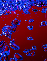 Image showing Close up view of the cold and fresh cola with bright bubbles in neon light