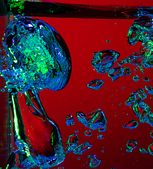 Image showing Close up view of the cold and fresh cola with bright bubbles in neon light