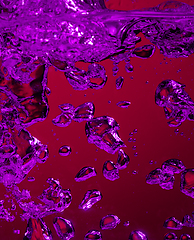 Image showing Close up view of the cold and fresh cola with bright bubbles in neon light