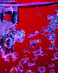 Image showing Close up view of the cold and fresh cola with bright bubbles in neon light