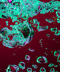 Image showing Close up view of the cold and fresh cola with bright bubbles in neon light