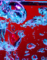 Image showing Close up view of the cold and fresh cola with bright bubbles in neon light