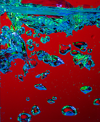 Image showing Close up view of the cold and fresh cola with bright bubbles in neon light