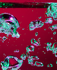 Image showing Close up view of the cold and fresh cola with bright bubbles in neon light