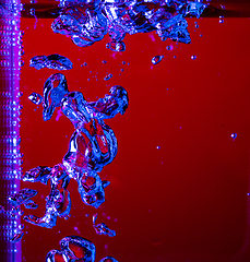 Image showing Close up view of the cold and fresh cola with bright bubbles in neon light