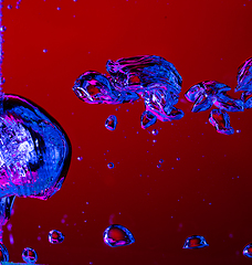 Image showing Close up view of the cold and fresh cola with bright bubbles in neon light