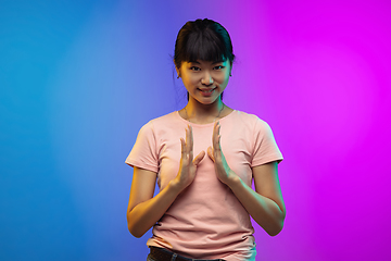 Image showing Asian young woman\'s portrait on gradient studio background in neon