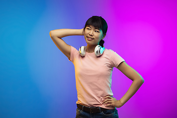 Image showing Asian young woman\'s portrait on gradient studio background in neon