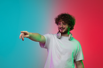 Image showing Caucasian young man\'s portrait on gradient studio background in neon