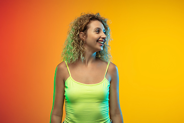 Image showing Caucasian young woman\'s portrait on gradient studio background in neon