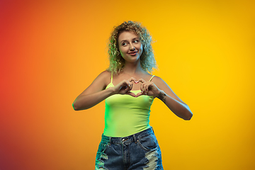 Image showing Caucasian young woman\'s portrait on gradient studio background in neon