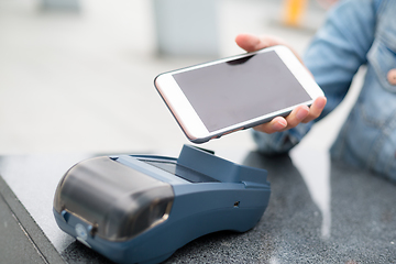 Image showing Woman paying with NFC technology on mobile phone