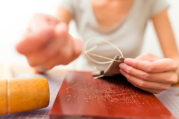 Image showing Leather handbag craftsman at work in a workshop