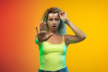 Image showing Caucasian young woman\'s portrait on gradient studio background in neon