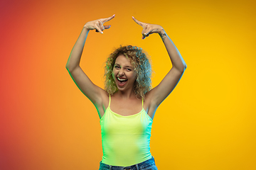 Image showing Caucasian young woman\'s portrait on gradient studio background in neon