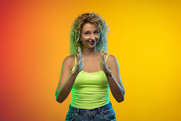 Image showing Caucasian young woman\'s portrait on gradient studio background in neon