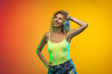 Image showing Caucasian young woman\'s portrait on gradient studio background in neon