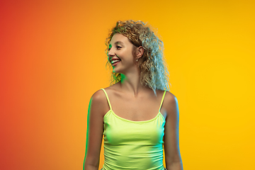 Image showing Caucasian young woman\'s portrait on gradient studio background in neon