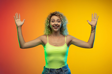 Image showing Caucasian young woman\'s portrait on gradient studio background in neon