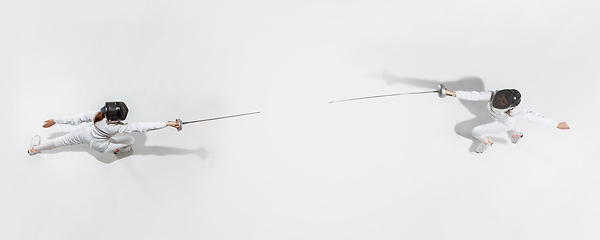 Image showing Teen girl in fencing costume with sword in hand isolated on white background, top view