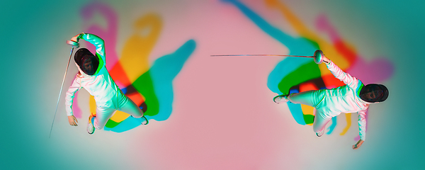 Image showing Teen girl in fencing costume with sword in hand on gradient background with neon light, top view