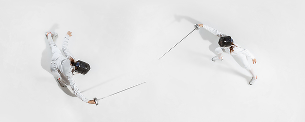 Image showing Teen girl in fencing costume with sword in hand isolated on white background, top view