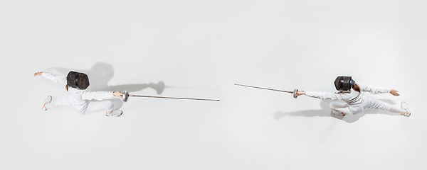 Image showing Teen girl in fencing costume with sword in hand isolated on white background, top view