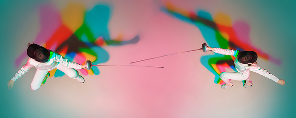 Image showing Teen girl in fencing costume with sword in hand on gradient background with neon light, top view