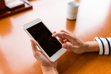 Image showing Finger using cellphone in restaurant