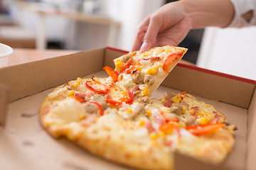 Image showing People taking one slice of pizza