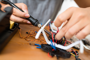 Image showing Connecting the parts of drone with welding tool