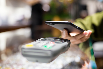 Image showing Woman paying with smartphone by NFC