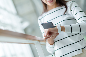 Image showing Woman using wearable watch connecting to cellphone