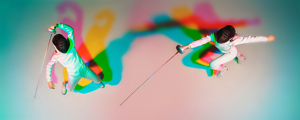 Image showing Teen girl in fencing costume with sword in hand on gradient background with neon light, top view