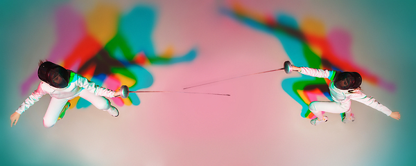 Image showing Teen girl in fencing costume with sword in hand on gradient background with neon light, top view