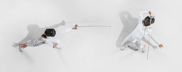 Image showing Teen girl in fencing costume with sword in hand isolated on white background, top view