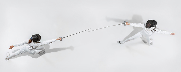 Image showing Teen girl in fencing costume with sword in hand isolated on white background, top view