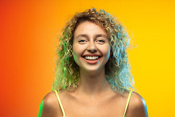 Image showing Caucasian young woman\'s portrait on gradient studio background in neon