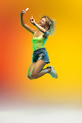 Image showing Caucasian young woman\'s portrait on gradient studio background in neon