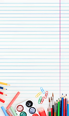 Image showing Colorful school supplies corner border over a lined paper background with negative space