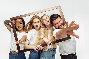 Image showing Group of adorable multiethnic friends having fun isolated over white studio background