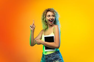 Image showing Caucasian young woman\'s portrait on gradient studio background in neon