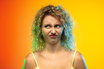 Image showing Caucasian young woman\'s portrait on gradient studio background in neon