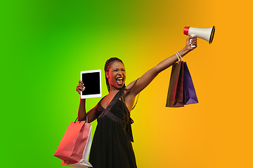 Image showing Portrait of young woman in neon light on gradient backgound. The human emotions, black friday, cyber monday, purchases, sales, finance concept.